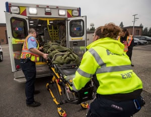 emt Paramedics loading patient into ambulance.